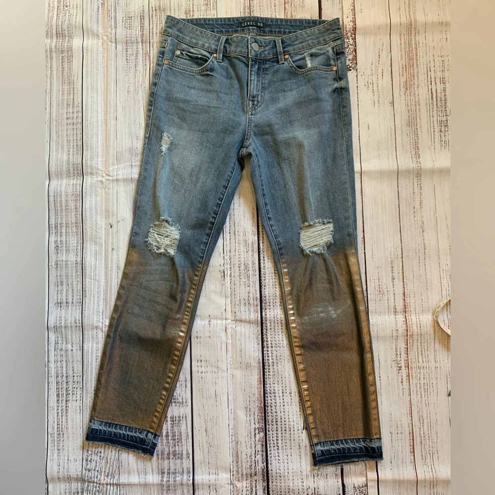 Level 99 jeans. Gold/silver design on bottom. Mid rise. Size 27.